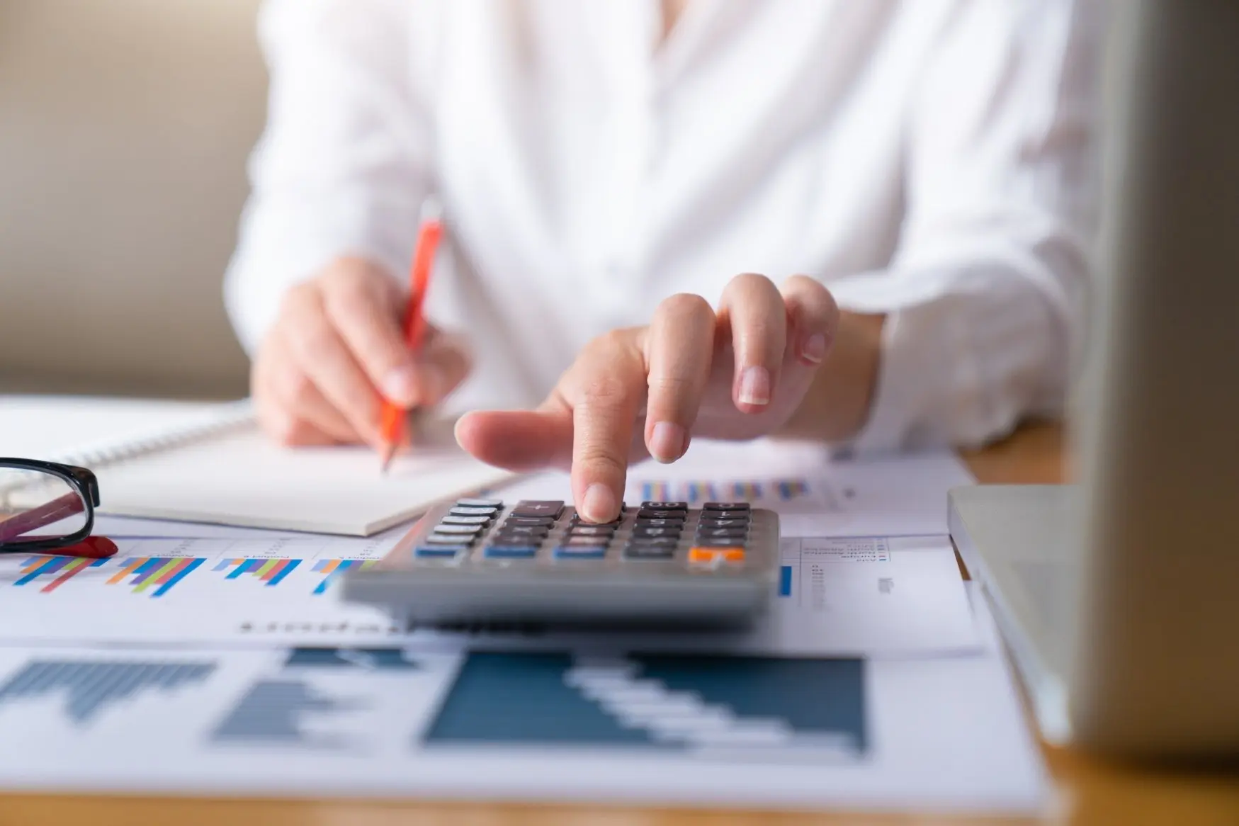 Woman using a calculator to create a budget