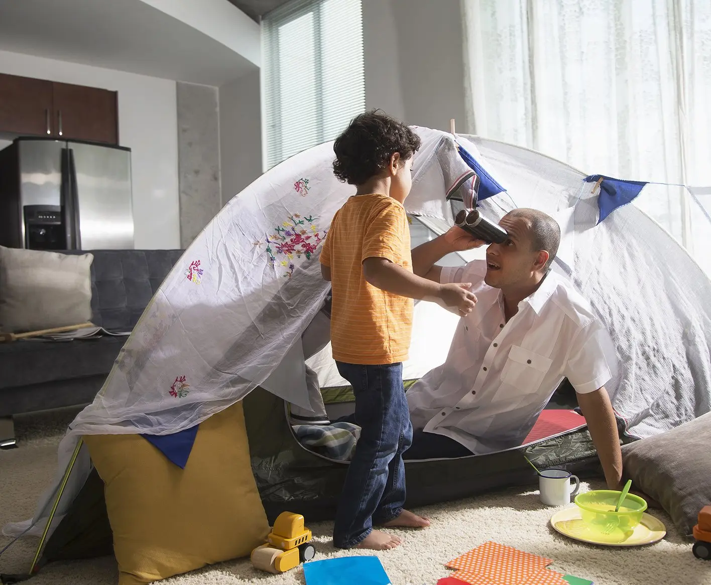 Father and son camping inside home
