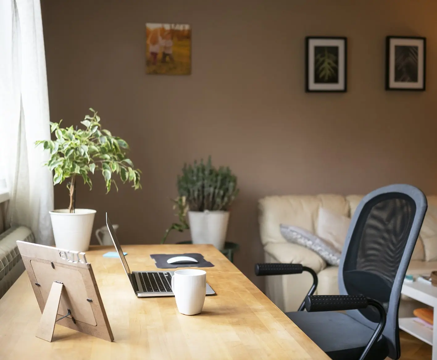 desk chair and laptop on a desk in a home office space