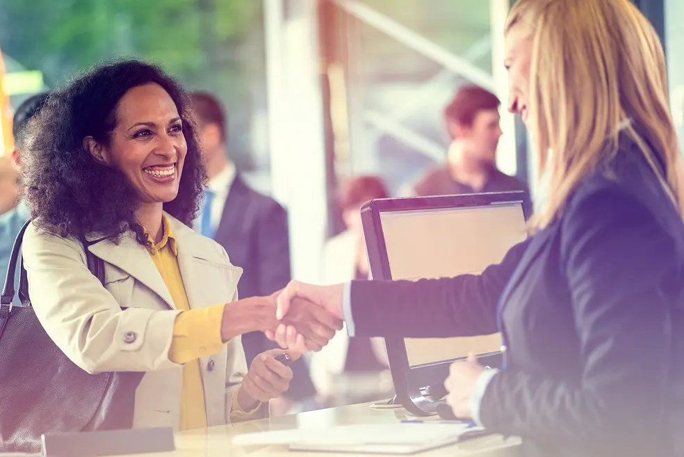 Two smiling women making a loan transaction