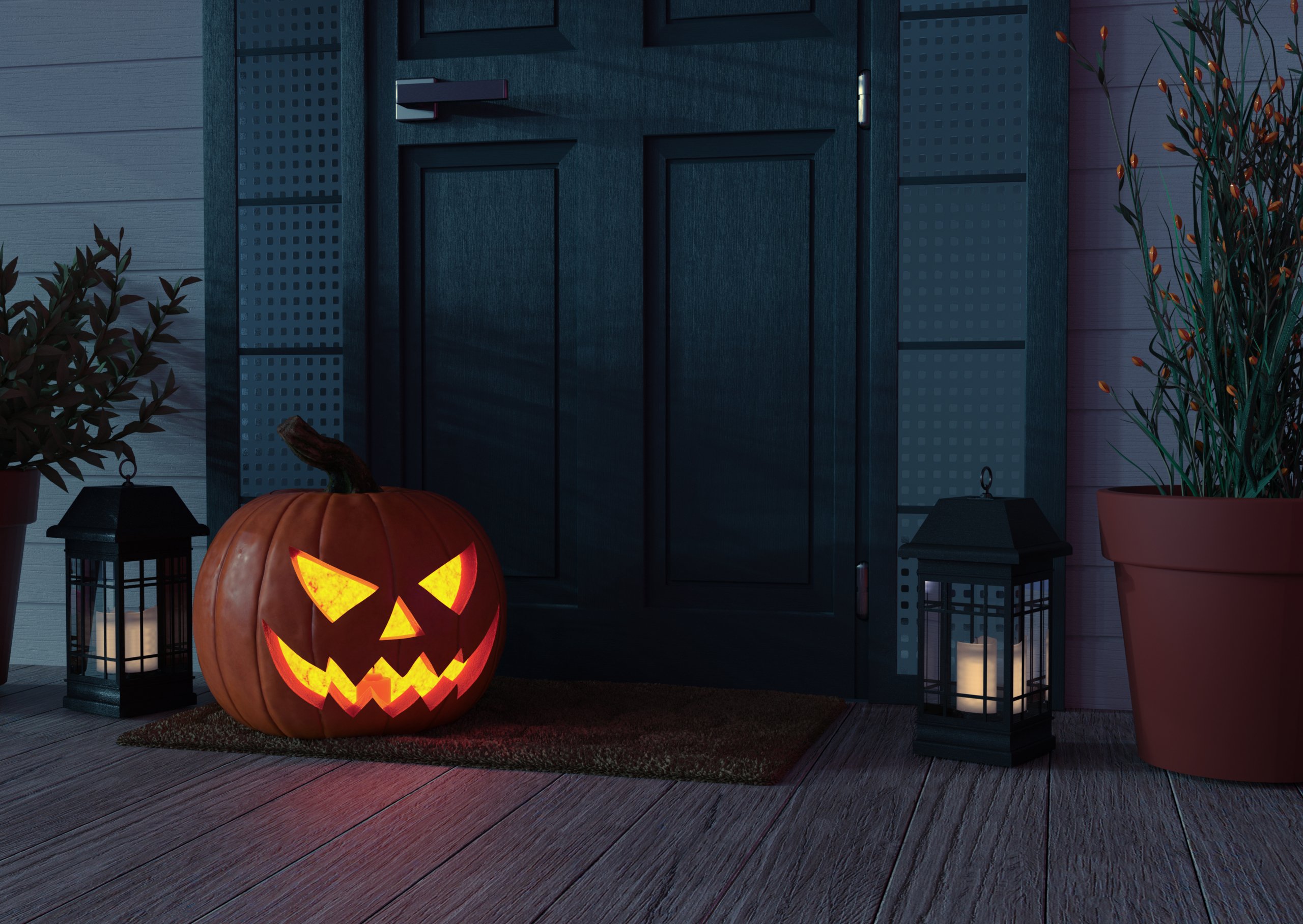 The home of a front porch decorated with a carved pumpkin and lanterns.