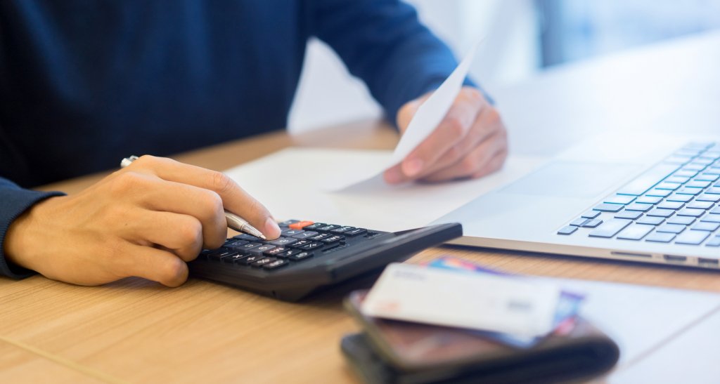 Man planning finances using a calculator 