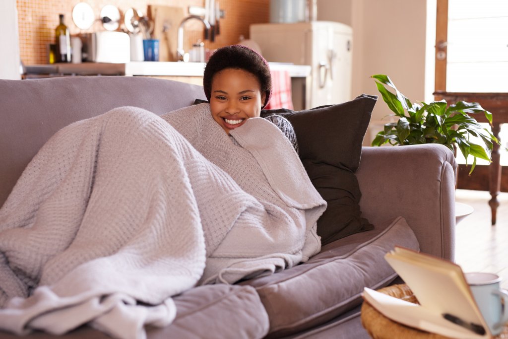 woman staying warm in winter with blanket