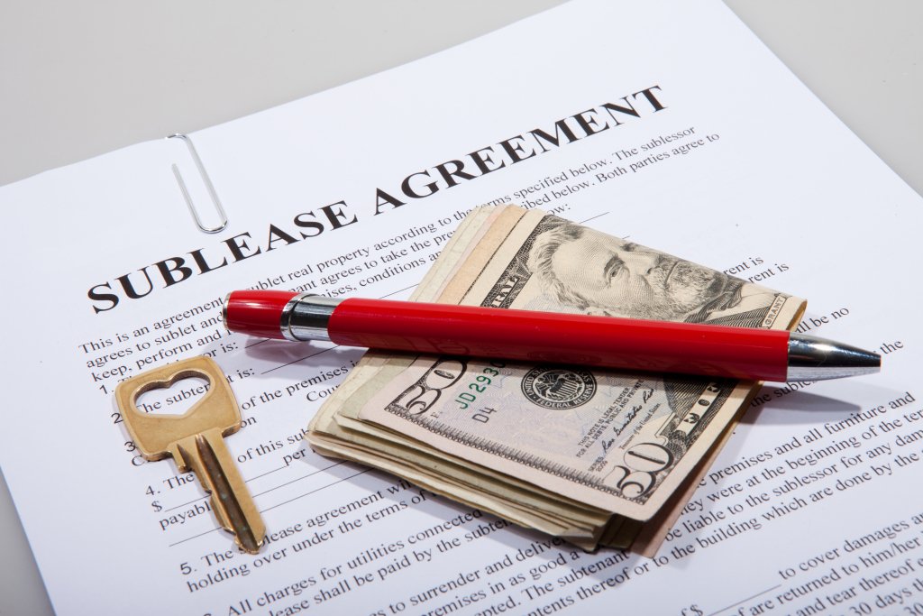 photo of apartment sublease agreement with money, a pen and a key