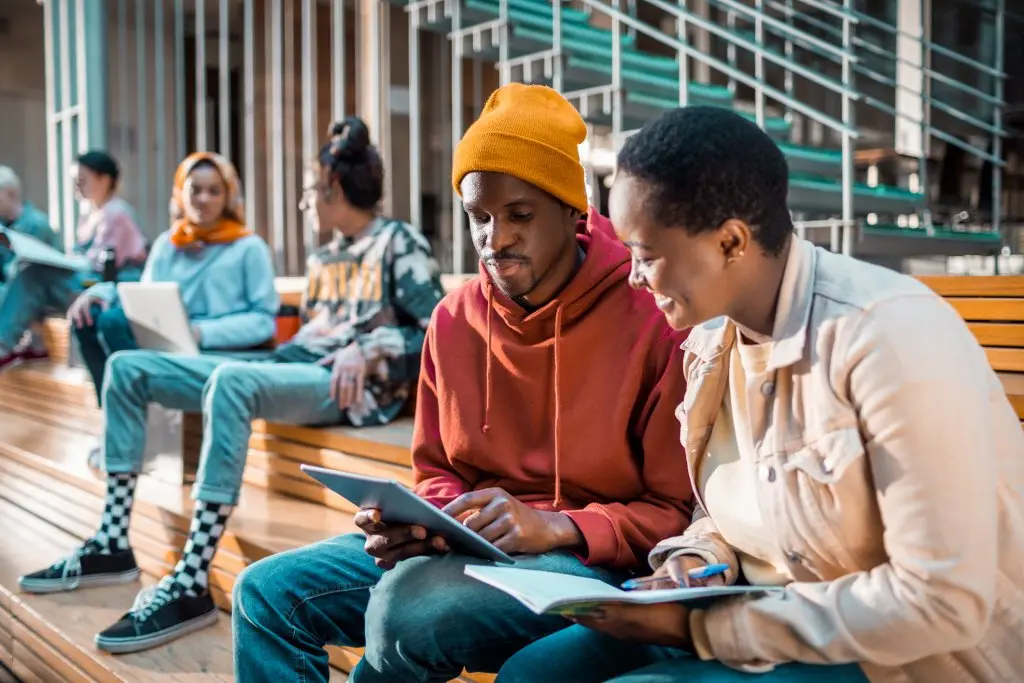 male and female college student studying together using an iPad 