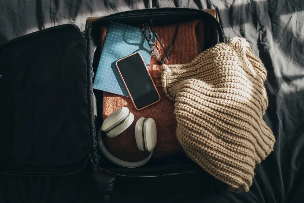 Packing up suitcase for vacation and preparing for a journey, flat lay