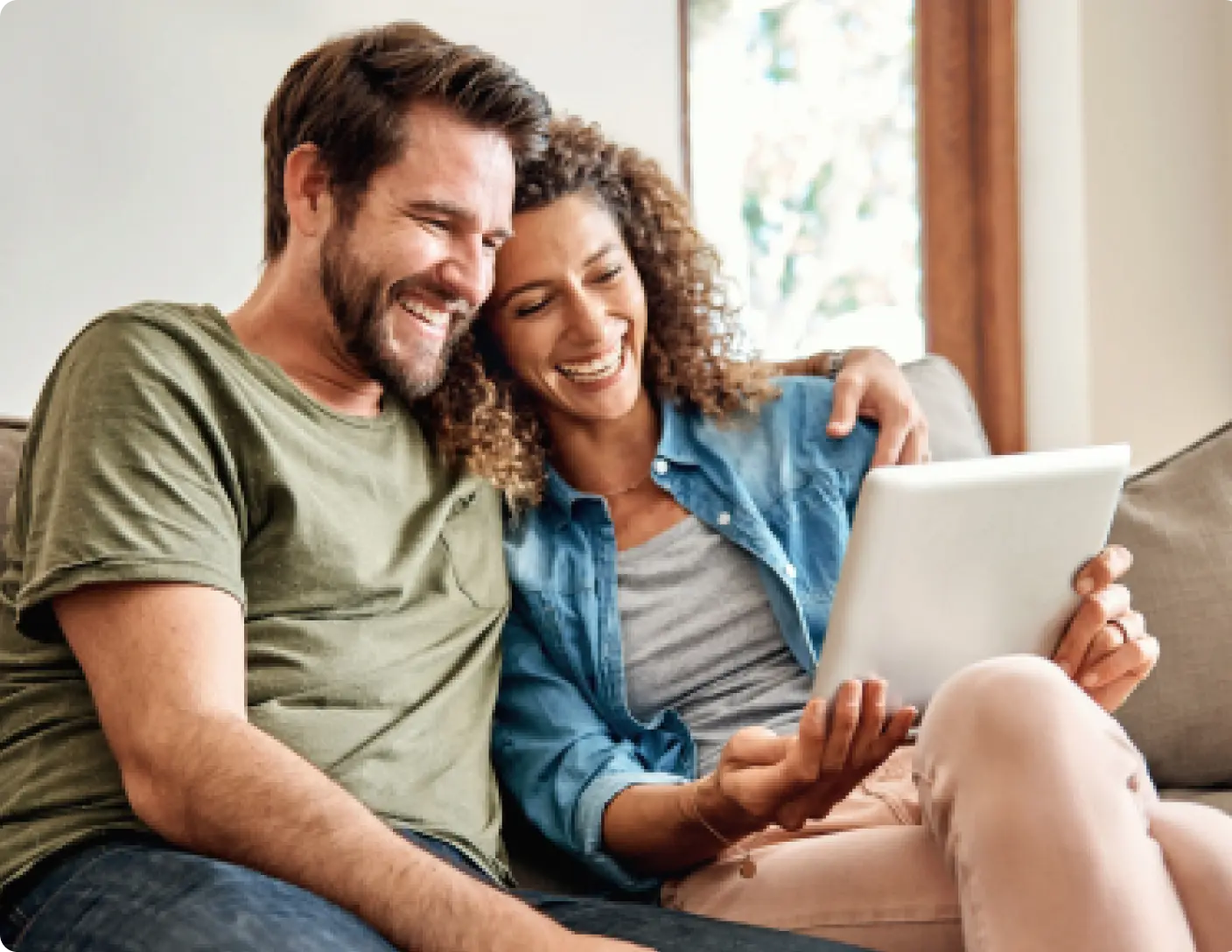 couple using tablet and laughing