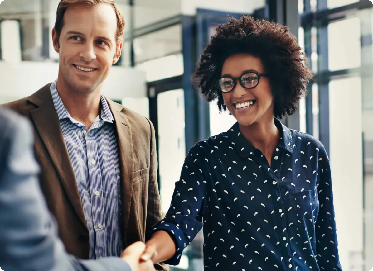 man next to woman shaking hands with someone off camera