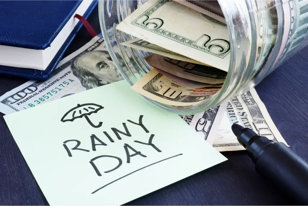 A container of dollar bills with a note that the funds are for a rainy day.