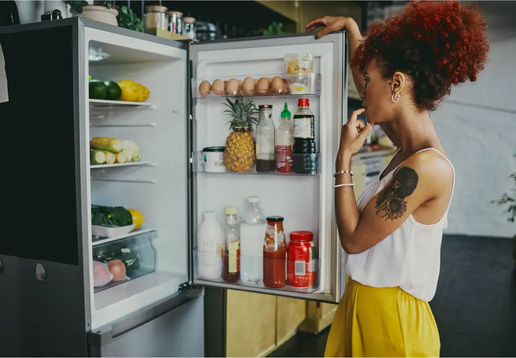 Woman looking in her fridge that has been financed