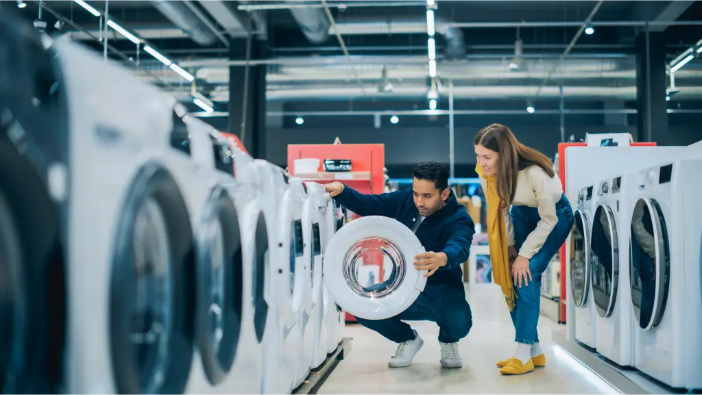 A couple looking at a washing machine together at an appliance store