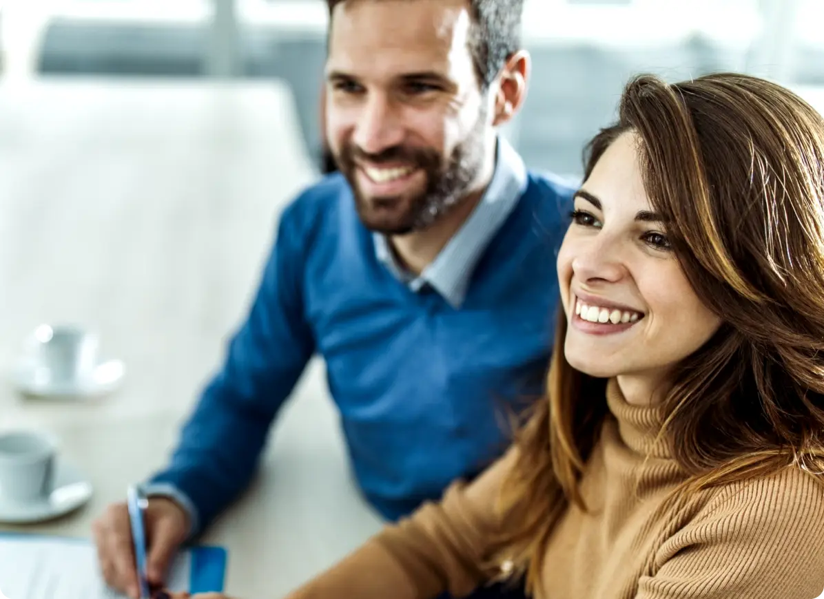 couple signing documents and smiling