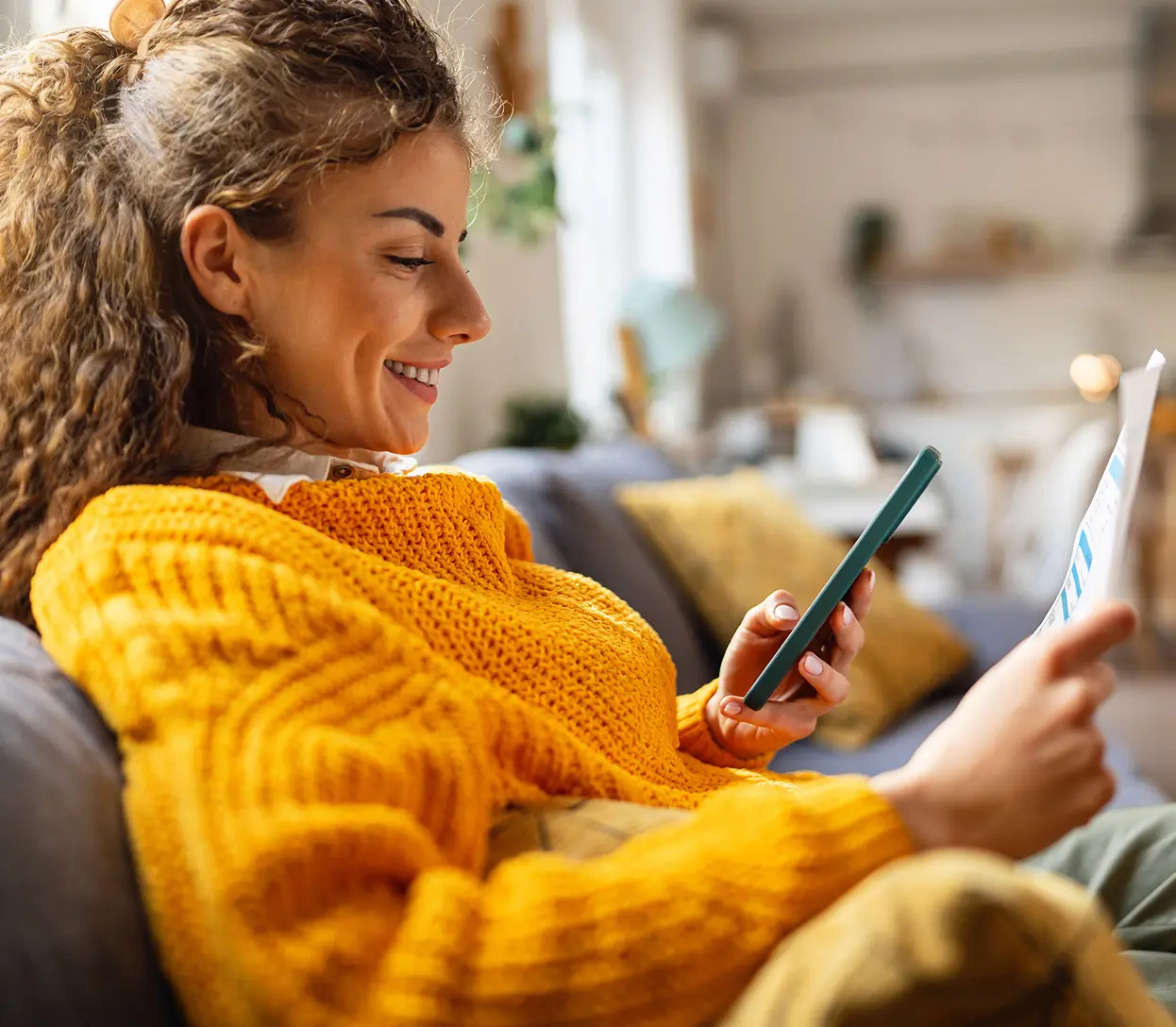 Woman in orange sweater using phone