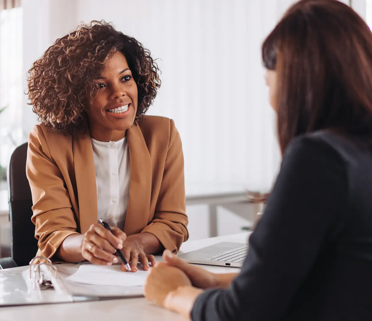 Two women sitting at desk going over paperwork