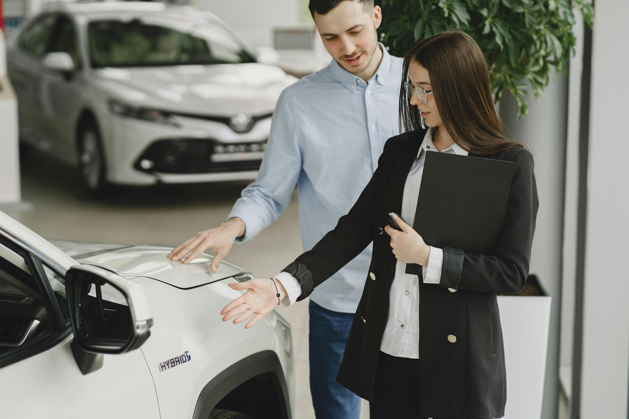 A man and woman are standing side by side in front of a car