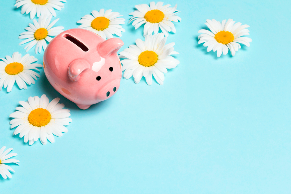 A piggy bank surrounded by flowers.